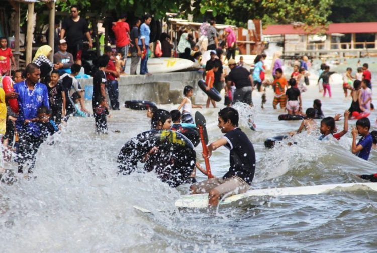 Warga Batam bermain di pantai Melayu Nongsa menikmati liburan, Minggu (1/1). F. Cecep Mulyana/Batam Pos