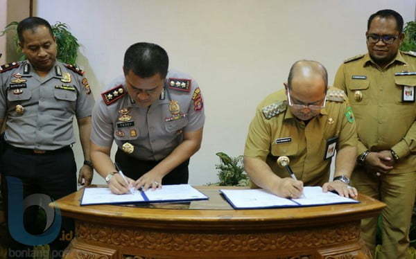 MINTA PENGAWALAN: Bupati Kutim Ismunandar (kanan) bersama Kapolres Kutim AKBP Teddy Ristawan (kiri) menandatangani nota kesepahaman tentang Penanganan Barang Milik Daerah.(Dhedy/Sangatta Post)