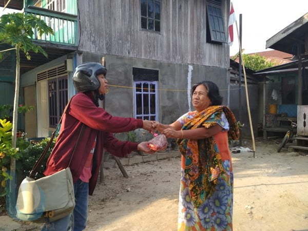BAGIKAN DAGING KURBAN: Pengurus AJKT membagikan daging kurban kepada warga Kampung Kajang.(Dhedy/ Sangatta Post)