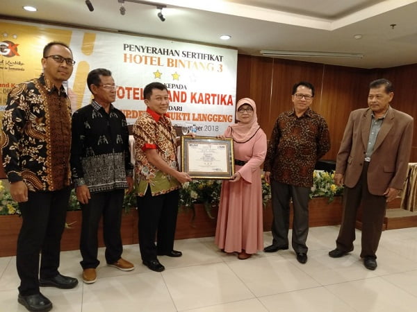 NAIK KELAS: Direktur LSUP Devys Mukti Langgeng, Sri Dewiastuti menyerahkan sertifikat sebagai bukti Hotel GK Samarinda telah naik kelas menjadi hotel bintang tiga, Rabu (12/9) lalu.(DEVI/METRO SAMARINDA)