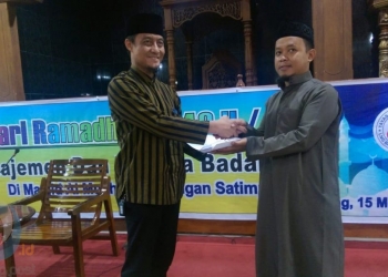 Ketua Yaumil LNG Badak, Bambang Budi Raharjo (kiri) menyerahkan bantuan untuk pembangunan masjid Al Muchtar. (Arsyad/Bontangpost.id)