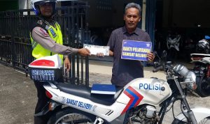 Salah satu tim Delivery Polres Bontang saat memberikan surat kendaraan kepada pemiliknya. (Polres Bontang for Bontangpost.id)