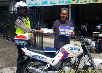 Salah satu tim Delivery Polres Bontang saat memberikan surat kendaraan kepada pemiliknya. (Polres Bontang for Bontangpost.id)