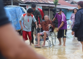 Seorang warga Guntung Jalan Tari Gong yang alami lumpuh dievakuasi warga dan petugas. (Arsyad)