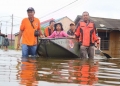 DERITA IBU KOTA: Petugas BPBD Samarinda mengevakuasi warga yang rumahnya terendam banjir di Jalan Terong, Samarinda Utara kemarin. Tampak rumah yang sudah ditinggal penghuninya. (RESTU/KP)