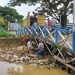 Petugas kebersihan Dinas Lingkungan Hidup Bontang tengah membersihkan sampah yang tersangkut di jembatan. (Pemkot Bontang)