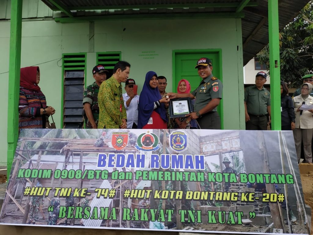 Letkol Arm Eko Pristiono (kanan) memberikan kunci rumah kepada Nirmala Dewi usai Kodim 0908 melakukan merenovasi rumahnya.(Zaenul/bontangpost.id)