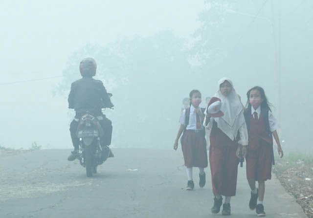 Akibat asap tebal yang menyelimuti Kota Palembang, Senin (14/10), siswa SD dan SMP diliburkan hingga dua hari ke depan. (KRIS SAMIAJI/SUMETERA EKSPRES)