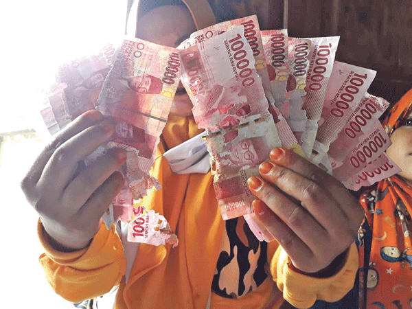 Lina, warga Kotawaringin Lama menunjukan uang rusak dimakan rayap. Dia berharap uangnya bisa ditukarkan uang baru di bank.(GUSTI HAMDAN/RADAR PANGKALAN BUN)