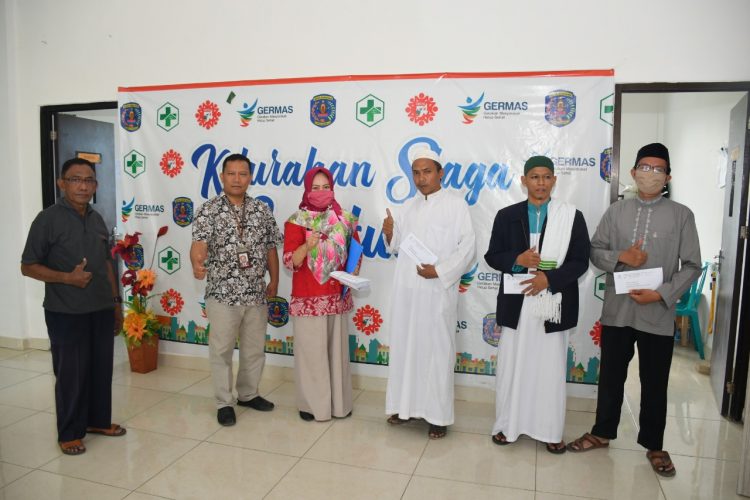 Ketua UPZ Pupuk Kaltim, Nur Sahid (dua dati kiri) didampingi pengurus, menyerahkan bantuan langsung ke Kelurahan Guntung. (Humas Pupuk Kaltim)