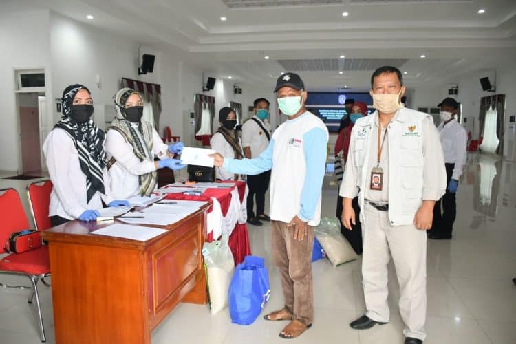 Penyerahan paket sembako secara simbolis kepada penerima bantuan, didampingi Ketua UPZ Pupuk Kaltim Nur Sahid (kanan). (Humas Pupuk Kaltim)