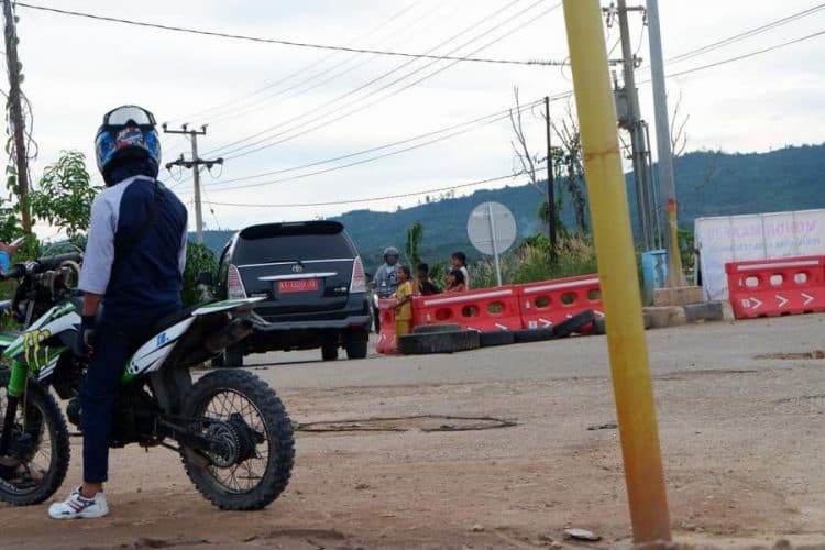 Sebanyak enam orang anak membantu membuka water barrier. Membawa kardus dan minta imbalan seikhlasnya pada pengemudi yang menerobos. (prokal)