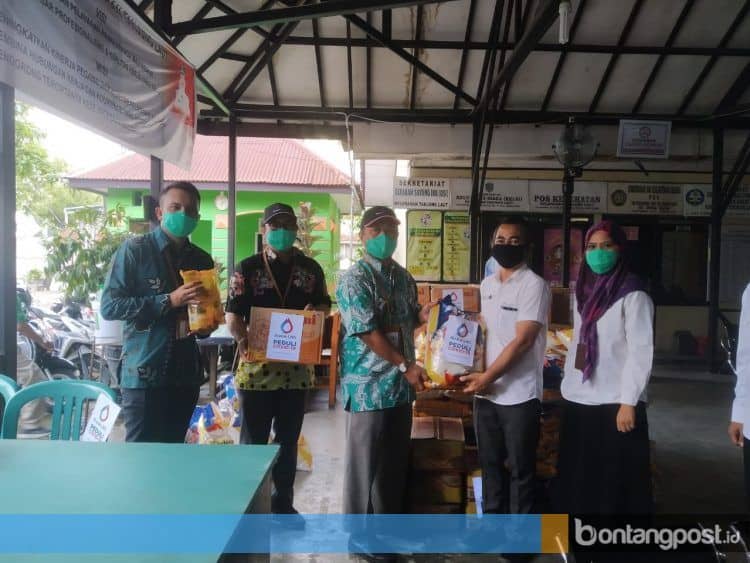 Manager CSR & Relations Corporate Communication Badak LNG, Bambang Eko Wibisono (kiri) menyerahkan paket sembako secara simbolis kepada perwakilan Kelurahan Tanjung Laut. (Fitri Wahyuningsih/Bontangpost.id)