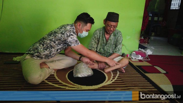 Herman Effendi memberikan bantuan kepada pasien sembari mengecek penggunaan obat dari resep dokter.