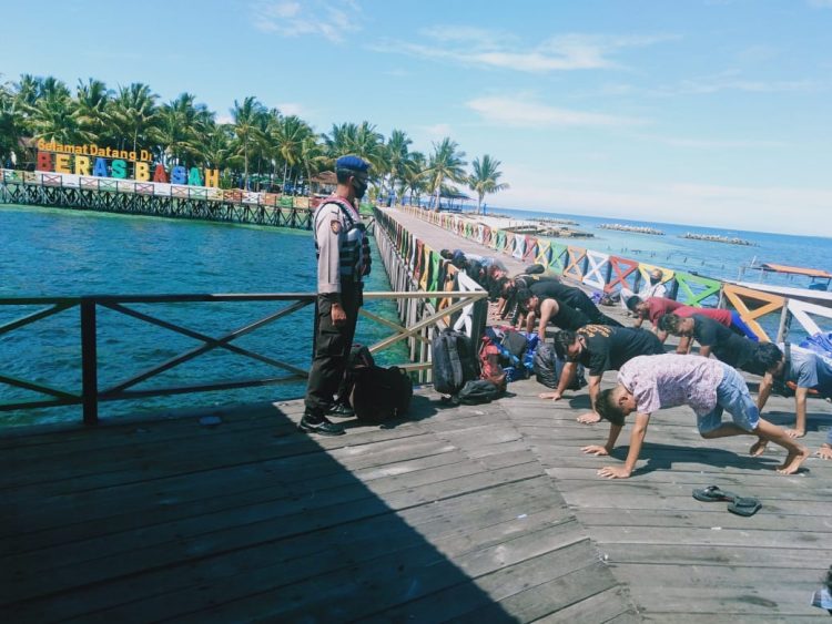 Petugas memberikan hukuman push-up kepada warga yang nekat ke Beras Basah.