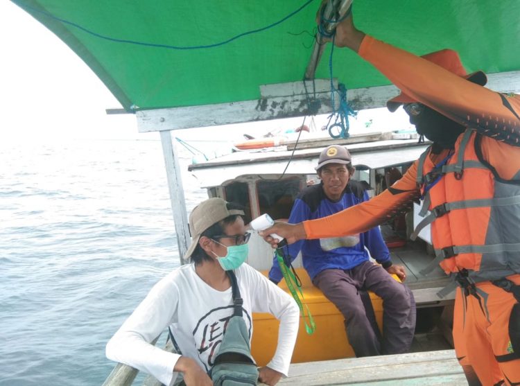 Petugas BPBD Bontang melakukan pengecekan suhu terhadap warga yang beraktivitas di laut. (BPBD Bontang for Bontangpost.id)