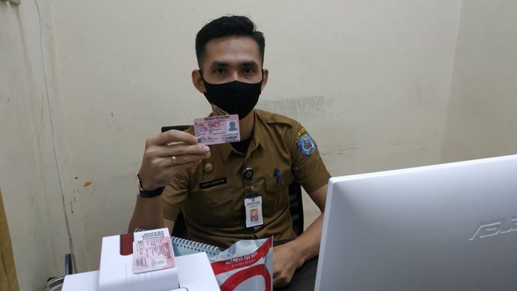 Salah satu pegawai Disdukcapil Bontang menunjukkan KIA yang telah dicetak. (Zaenul/Bontangpost.id)