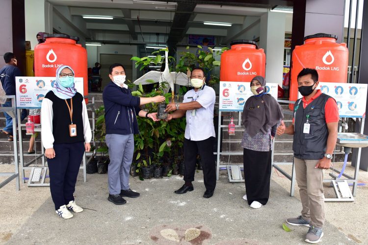 Spv Internal & External Relations Badak LNG, Rustam Effendi (dua dari kiri) menyerahkan bibit ulin secara simbolis kepada Kasubbag TU UPT Pasar Kota Bontang, Abdul Malik Rifa'i. (Corporate Communication Badak LNG)