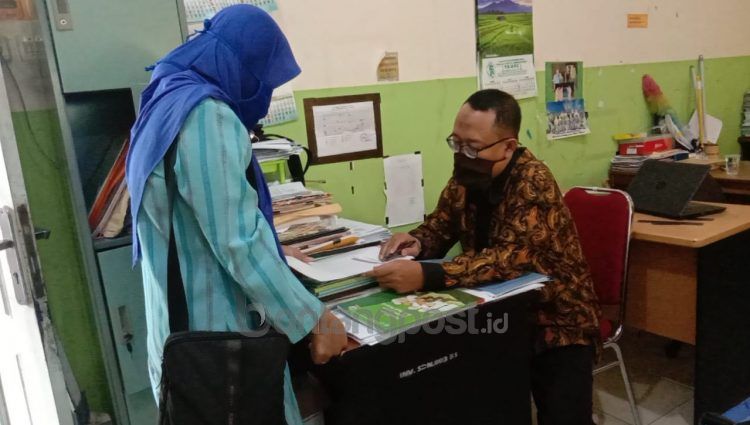 Salah satu orangtua di SDN 003 Bontang Selatan mengambil materi pembelajaran yang dicetak manual, mengingat tidak bisa menempuh skema pembelajaran daring. (Adiel Kundhara/KP)