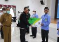 Kepala Kantor Cabang BPJAMSOSTEK Bontang Muhammad Romdhoni secara simbolis menyerahkan kartu kepesertaan BPJAMSOSTEK kepada perwakilan FKUB. (Andre/BPJAMSOSTEK Bontang)