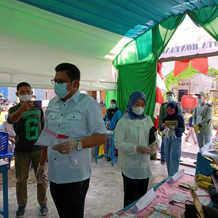 Basri Rase didamping sang istri Hapidah saat menyalurkan hak suara.