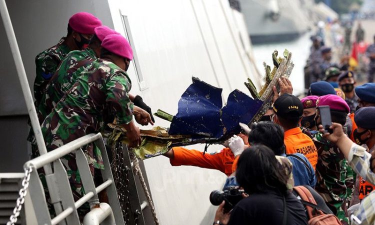 Anggota TNI dari kesatuan Marinir saat menurunkan serpihan pesawat Sriwijaya Air SJ 182 dan kantong jenazah yang berhasil dievakusi ke Dermaga, JICT 2, Jakarta, Minggu (10/1). Foto: Ricardo/JPNN.com