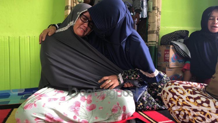 EDWIN AGUSTYAN/KP
Tangis Hadriani (kiri) pecah dipelukan kerabatnya. Dia berharap suaminya bisa segera ditemukan.