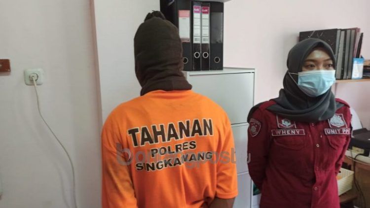 Tersangka AR (membelakangi lensa), pelaku pencabulan terhadap adik tirinya ditahan di Mapolres Singkawang. ISTIMEWA
