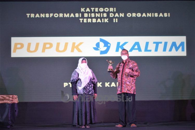 Membanggakan: SVP Sekretaris Perusahaan Pupuk Kaltim Teguh Ismartono (kanan) memegang piala penghargaan Terbaik II Kategori Transformasi Bisnis dan Organisasi dari BUMN Track. (Humas Pupuk Kaltim)