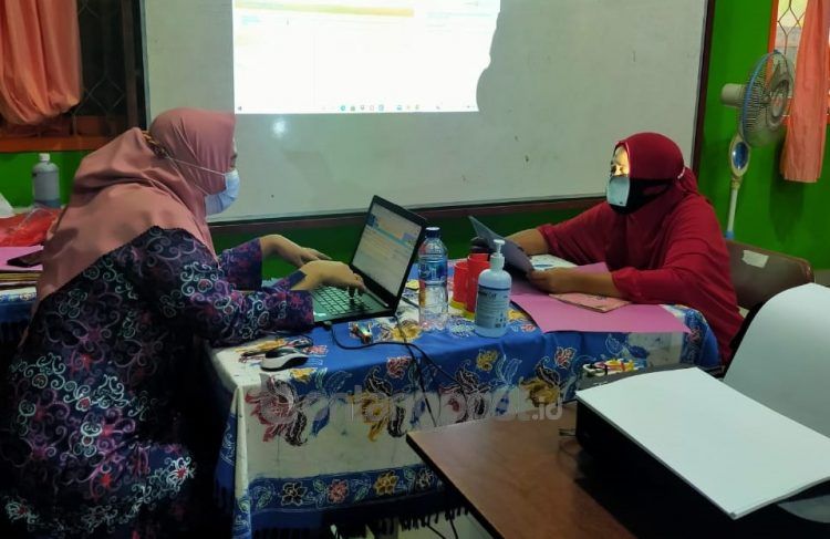 Operator SD 004 Bontang Utara melakukan validasi berkas penerimaan peserta didik baru (PPDB).