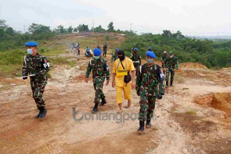 Mengenakan pakaian tahanan berwarna kuning dan topeng hitam, tersangka kembali menjalani rekonstruksi pembunuhan, Jumat (9/7) pagi.