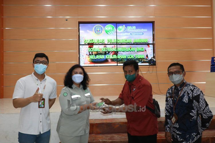 CSR Specialist & PR PT KPI Mery Juna (dua dari kiri) memberikan kartu kepesertaan BPJAMSOSTEK kepada perwakilan ketua RT. (PT KPI for Bontangpost.id)