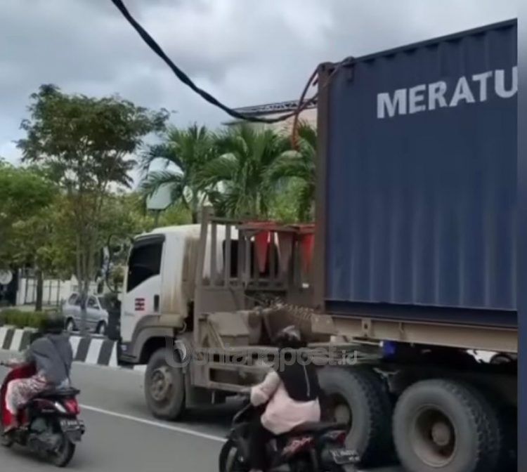 Tangkapan layar video truk kontainer tersangkut kabel listrik.