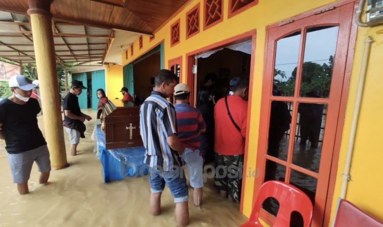 Pemakaman warga Gunung Telihan menunggu banjir surut (Nasrullah/bontangpost.id)