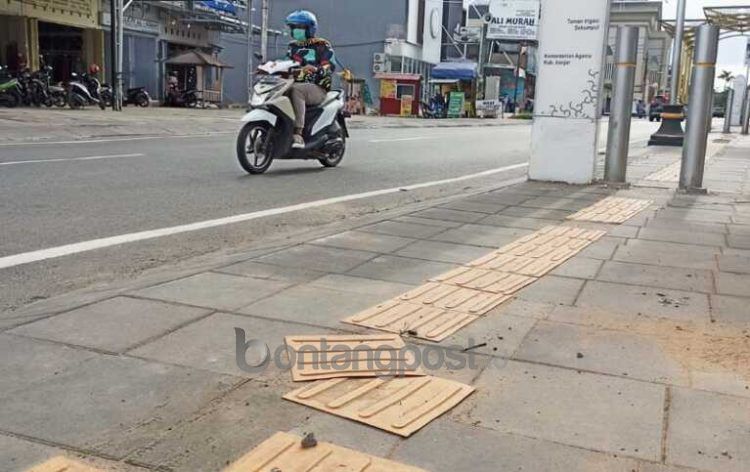 Ubin kuning untuk jalur penuntun penyandang disabilitas yang terlepas di trotoar Sekumpul. Foto: SUTRISNO/RADAR BANJARMASIN