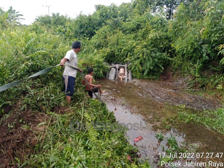 Warga mengevakuasi mobil dari lokasi kejadian. (Polsek Jabiren Raya)