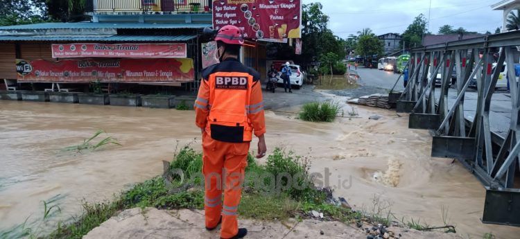 Situasi saat ini di km 5, air sungai meluap ke badan jalan.