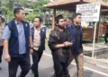 Samsudin dikeler menuju Ditreskrimsus Polda Jatim, Kamis (29/2) (Radar Surabaya/JPG)