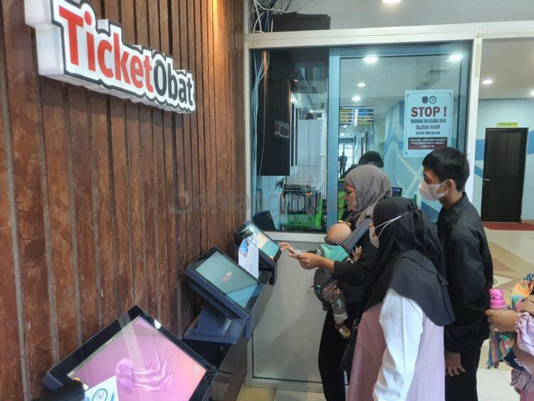 Salah Satu pengunjung terlihat mengisi survei kepuasan di gerai tiket obat di Lobi RSUD Taman Husada Bontang.