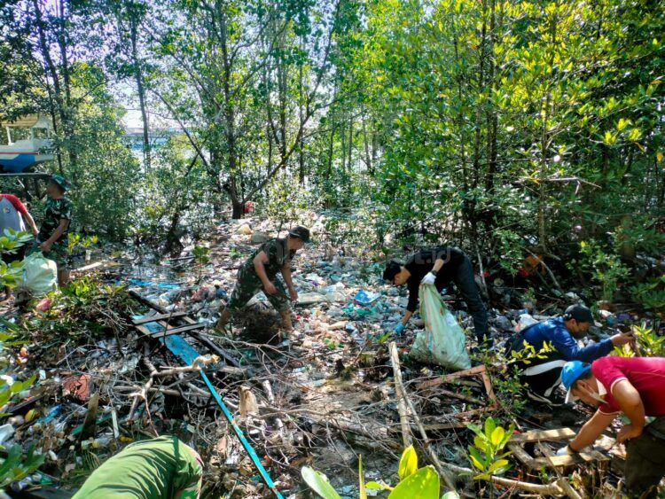 Kabid Pariwisata Dispopar Kota Bontang Muhammad Ihsan (baju hitam) saat melakukan pembersihan sampah di kawasan mangrove bersama pihak terkait (Jelita/bontangpost.id)