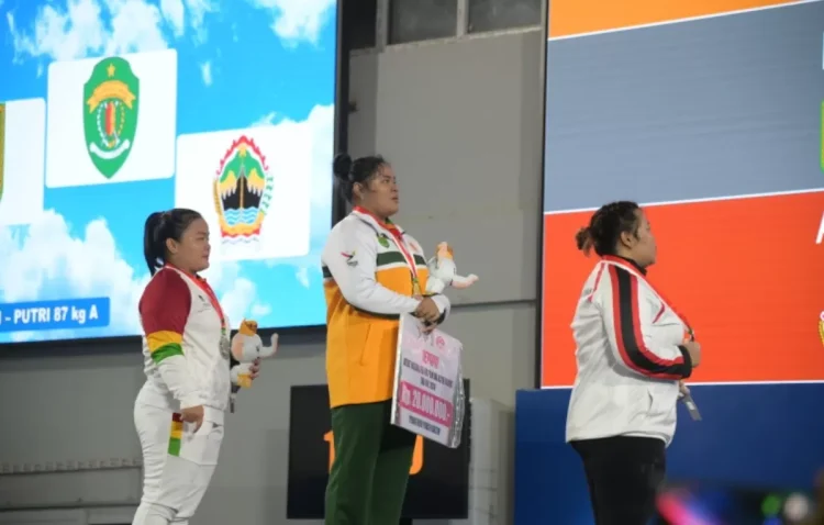 Lifter Kaltim Firda Khairunnisa (tengah) berhasil menyumbang medali emas PON untuk Kaltim. (FOTO: DONI ADITYA/KP)