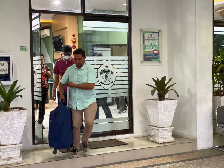 Petugas KPK keluar membawa koper yang diduga berisi dokumen dari DPMTSP Kaltim. (Foto: Dwi Restu/KP)