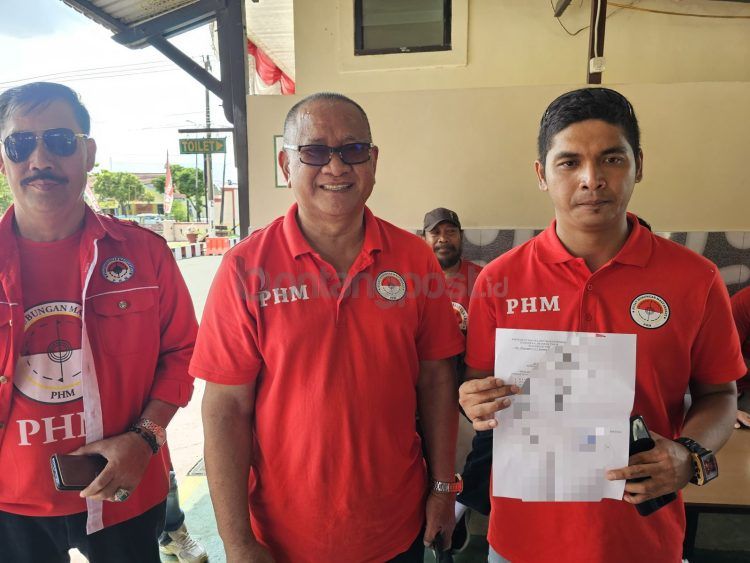 Risfani (kanan) dan Udin Mulyono (tengah) selepas melapor di Polres Bontang.