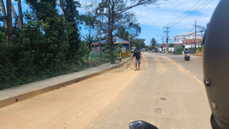 Salah satu pekerja proyek menyapu pasir yang tumpah. (Dwi Kurniawan/Bontang Post)