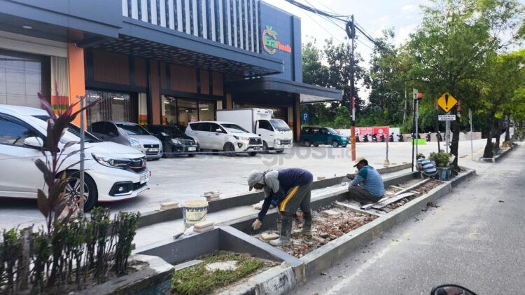 Pekerja Era Fresh Bontang melakukan pengerjaan perbaikan trotoar yang sebelumnya dijadikan tempat parkir. (Dwi Kurniawan Nugroho/Bontang Post)