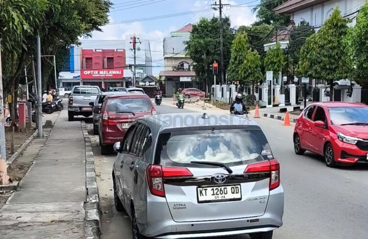 Kendaran mobil yang terparkir di dua sisi di Jalan MH Thamrin tepatnya di depan Kantor Bapenda dan BPKAD Bontang memakan badan jalan (Nasrullah / Bontang Post)