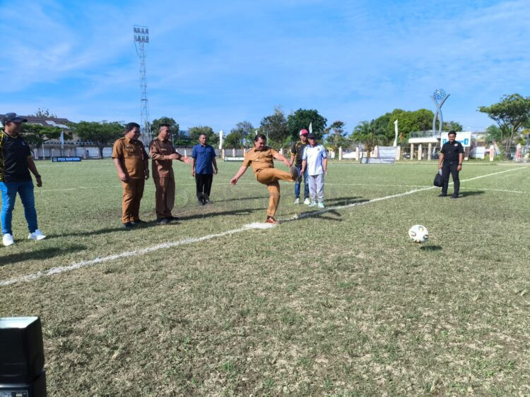 Wakil Wali Kota Bontang, Agus Haris, membuka pertandingan dengan tendangan bebas di Lapangan Besai Berinta. (Dwi Kurniawan Nugroho/Bontang Post)