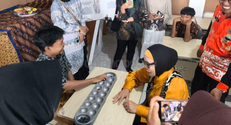 Wali Kota Bontang Neni Moerniaeni mencoba salah satu permainan tradisional yakni coklak bersama murid SMP Negeri 7 Bontang di Festival Bulan Bahasa. (Dwi Kurniawan Nugroho/Bontang Post)