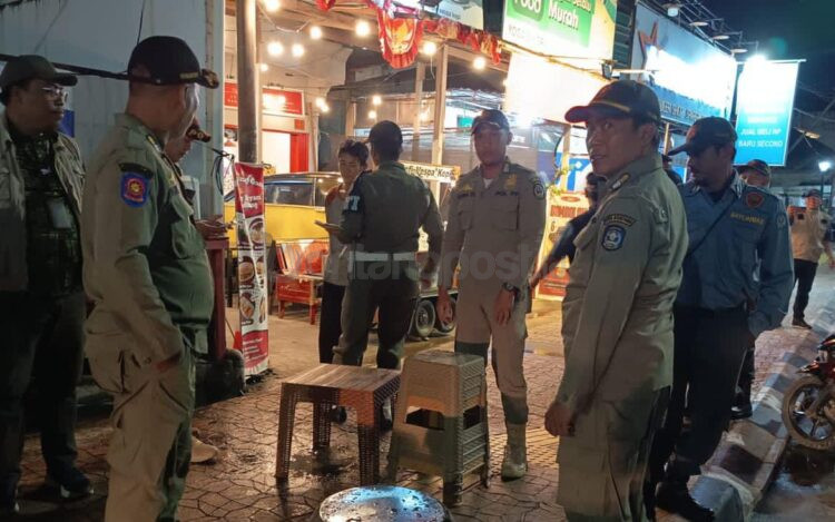 Satpol PP Bontang menertibkan kursi dan meja pedagang yang berada di trotoar Jalan Ahmad Yani, Jumat (14/11/2025).