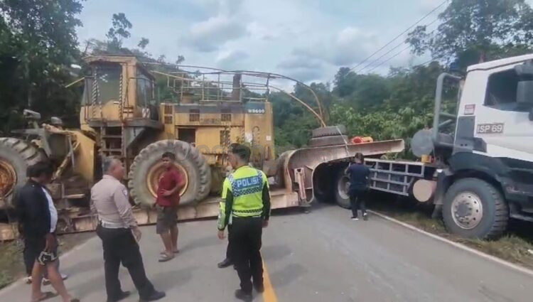 Petugas kepolisian menunggu alat evakuasi truk yang melintang di jalan poros Samarinda dekat simpang Marangkayu. (Polres Bontang)